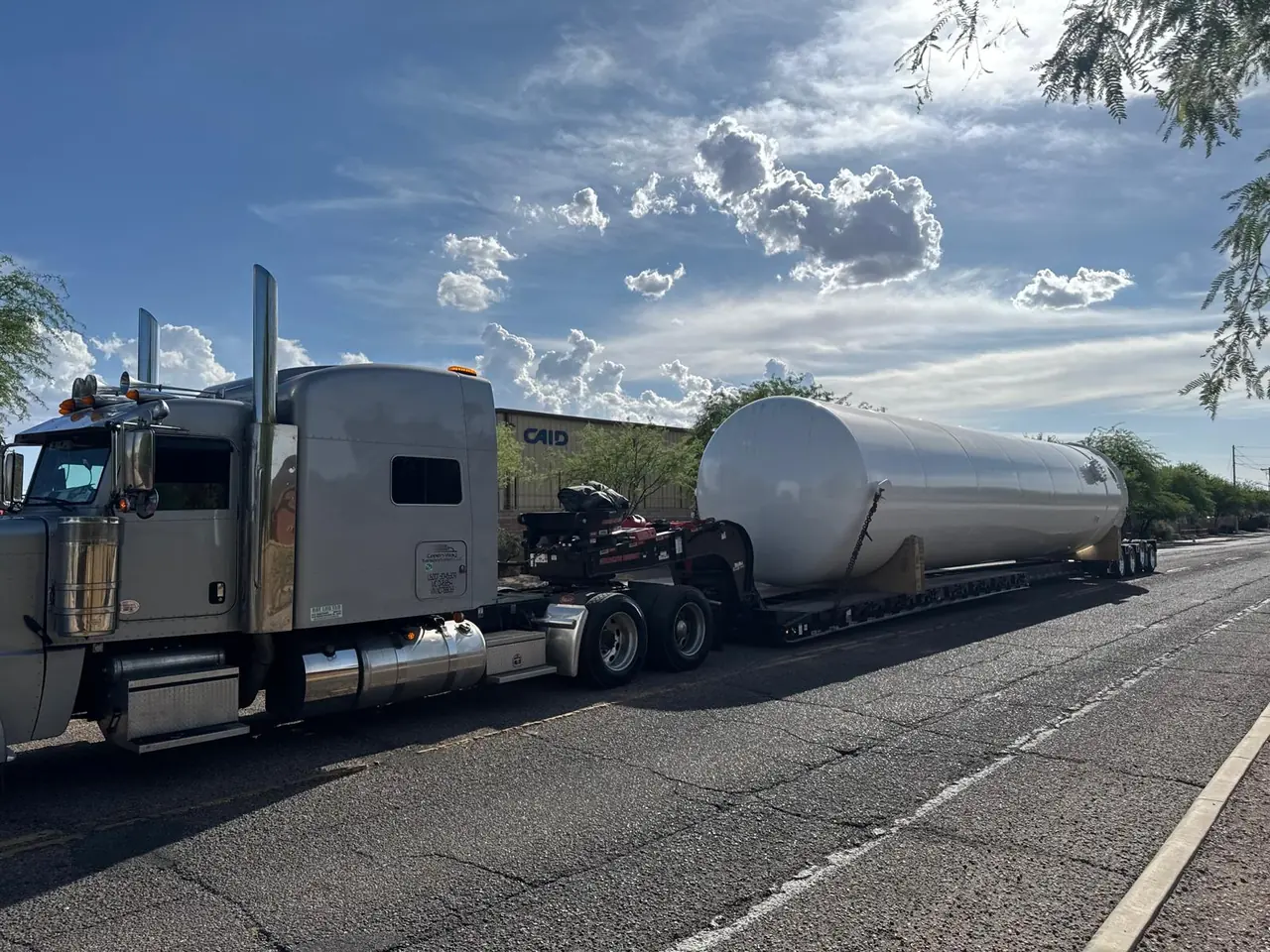 Green Way truck hauling a large cylindrical industrial tank on a trailer