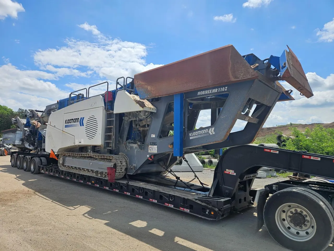 Kleemann mobile crusher secured with chains on a lowboy trailer